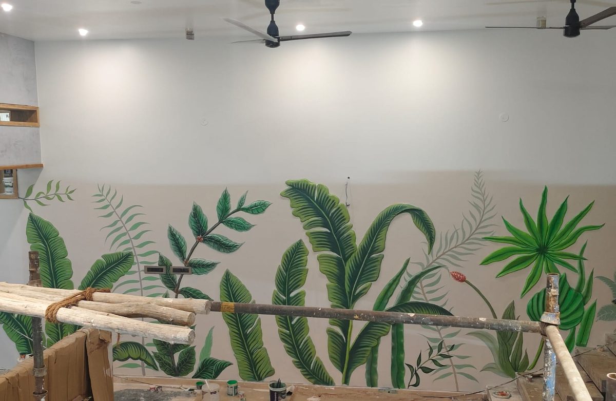 Hand-painted botanical leaf mural along a wall