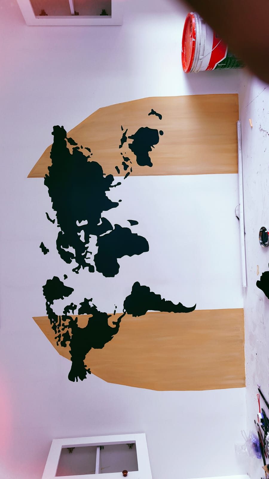 World map mural painted in charcoal and wood-tone bands