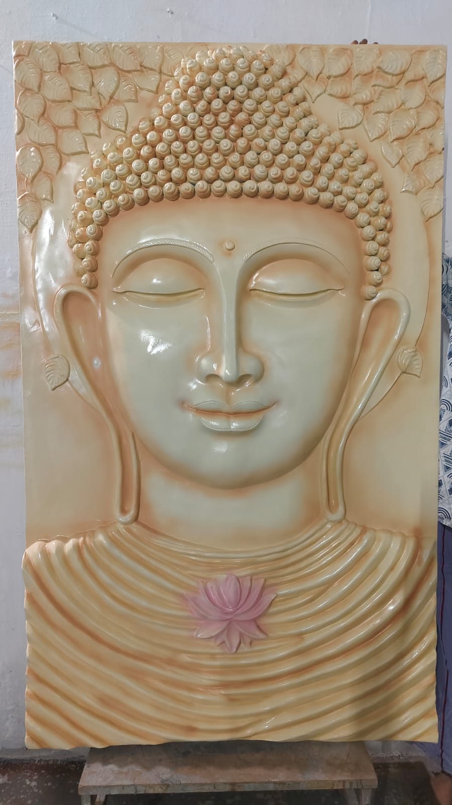 Cream-toned 3D relief sculpture of Buddha's face with a lotus